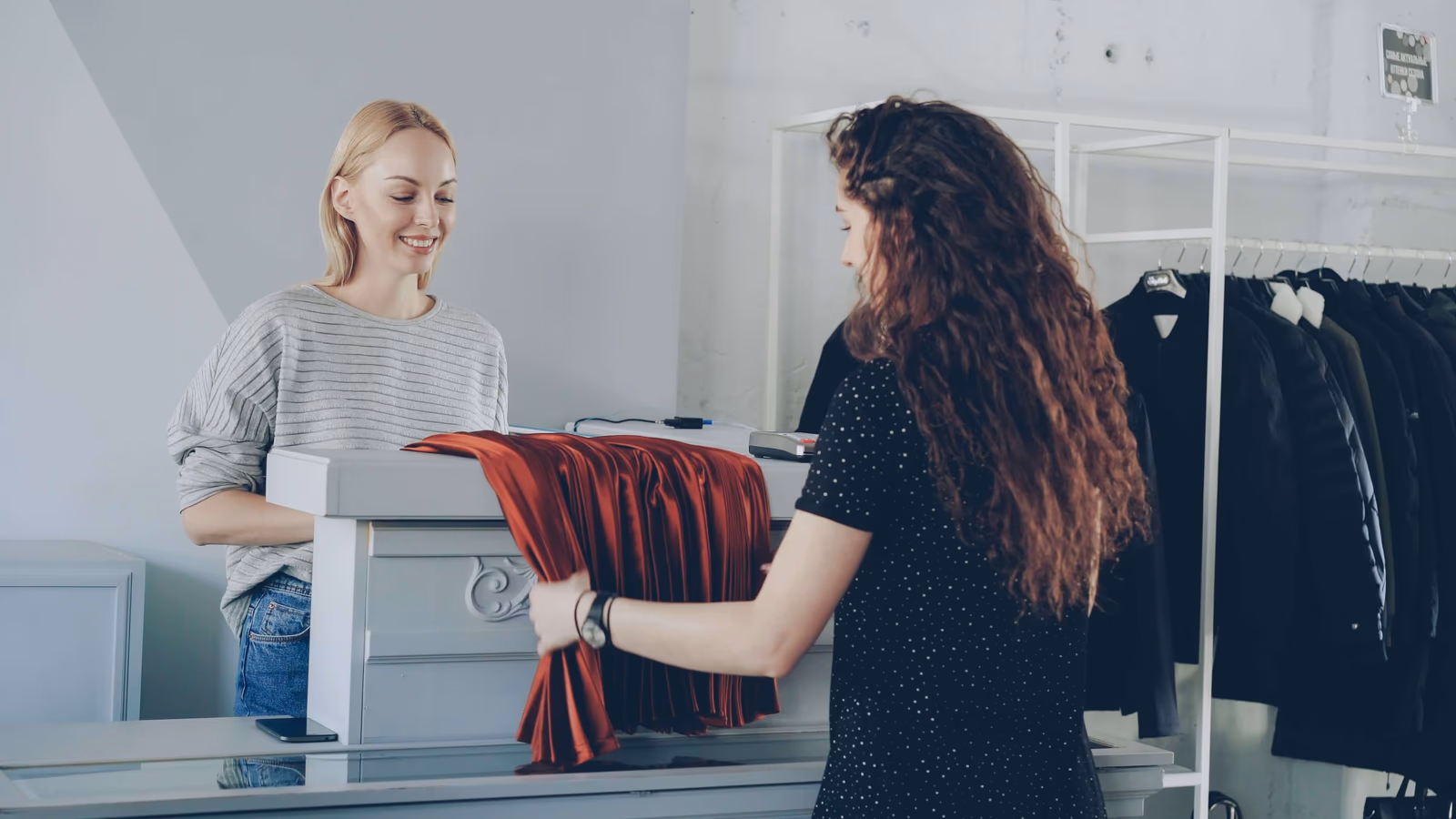 A retail assistant helping a customer at the counter