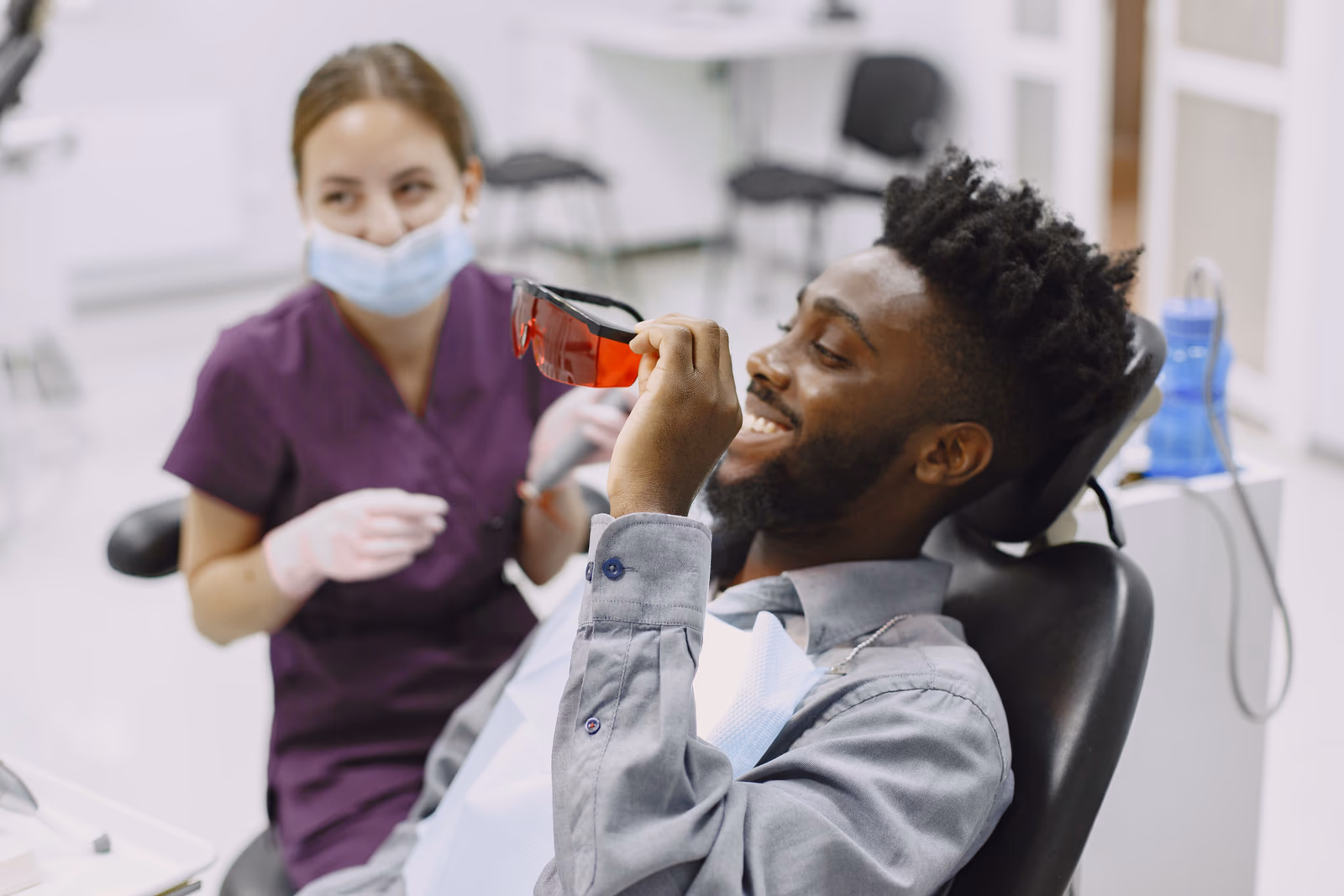 A patient smiling with their dentist during treatment